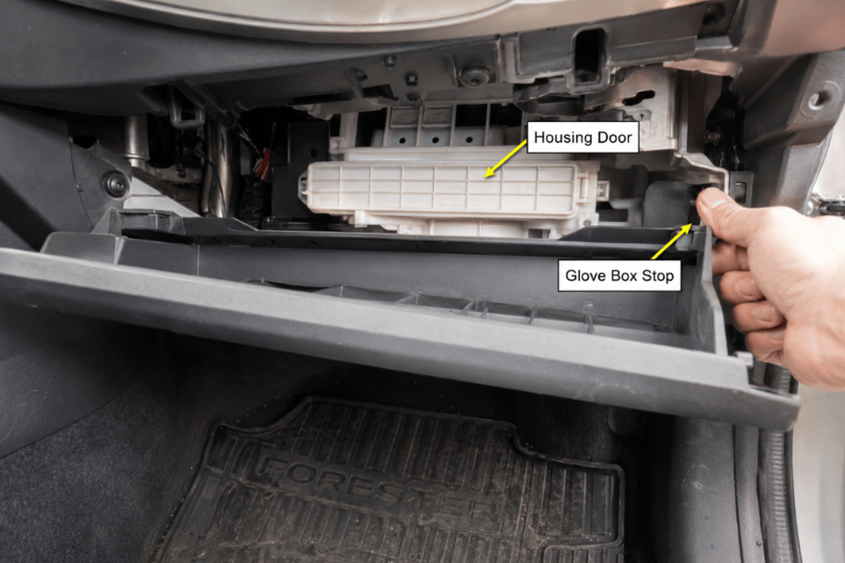 Subaru Forester glove box lowered to expose the cabin air filter housing behind it.