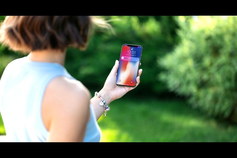 View of woman holding a mobile phone showing a reminder to change air filters