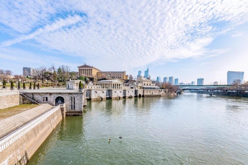 Cities Where Remote Workers Log the Most Hours - Images of a panoramic view of the Schuylkill River with the Philadelphia skyline in the background, showcasing historic architecture and modern city buildings.