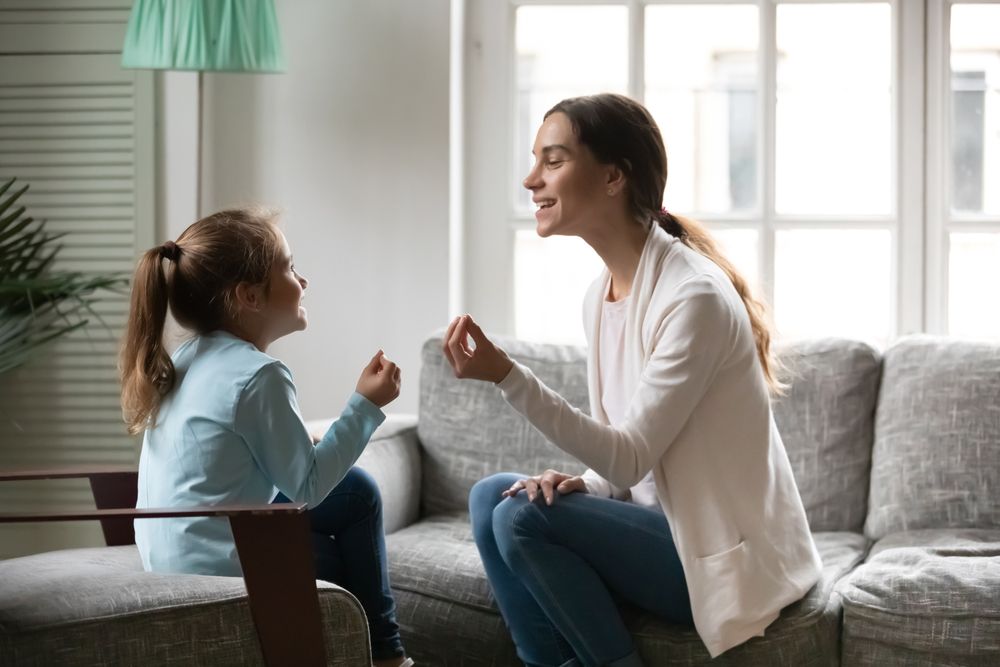 Image of a speech therapist working with a young girl on the couch