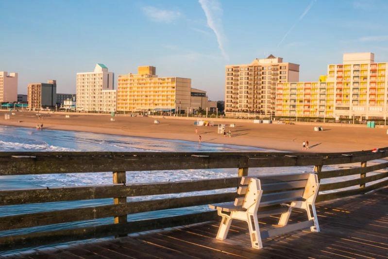 Cities with the Biggest Declines in Air Pollution - Image of a beachfront view with chairs overlooking the ocean, buildings in the background during sunset at Virginia Beach.