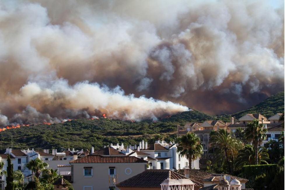 Thick smoke and flames from a wildfire threatening hillside homes in California