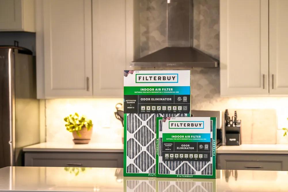 A view of Filterbuy indoor air filter packaging on a kitchen counter, showcasing cut-to-fit furnace and HVAC carbon air filter material.