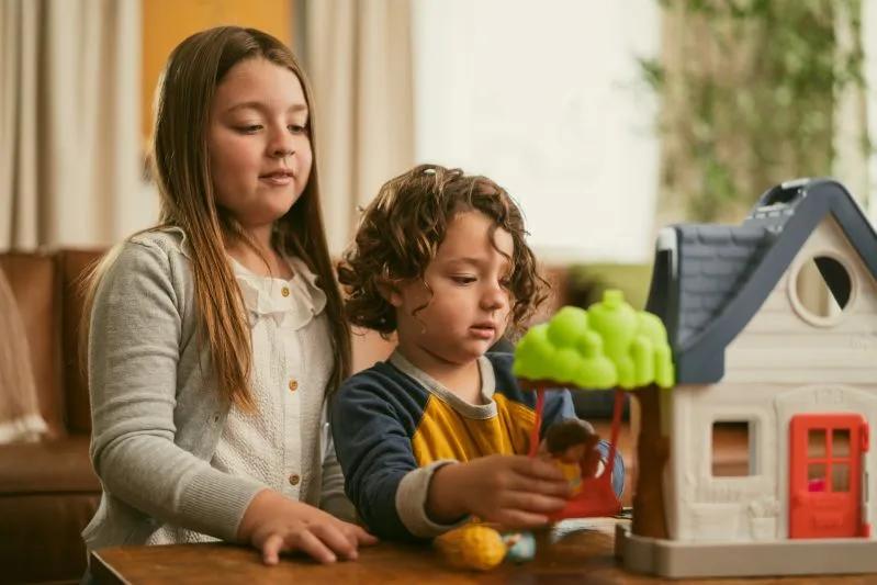 A view of a young girl and boy playing together indoors with educational toys, highlighting a clean and healthy home environment.