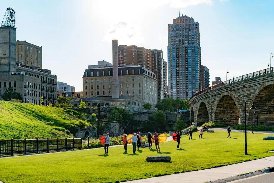 Image of modern high-rise buildings in Minneapolis with some elderly enjoiying an active lifestyle o the public park.