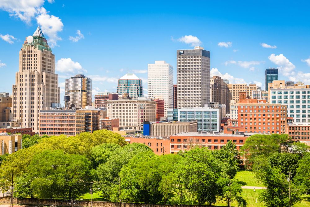  Downtown skyline featuring a mix of historic and modern buildings, with a park in the foreground.