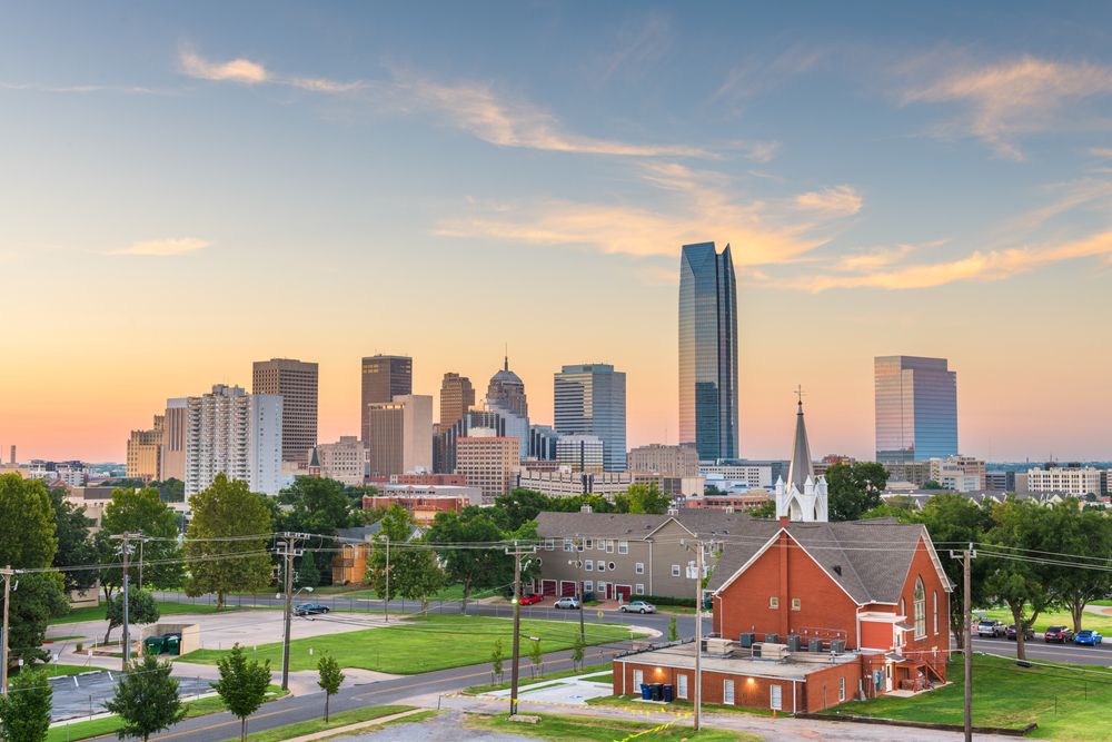 Oklahoma City skyline at sunset with a red brick church.