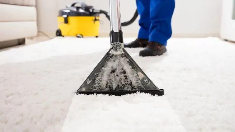 How to See Dust Mites in Your Mattress - image of a professional cleaning a white carpet with a steam cleaner.
