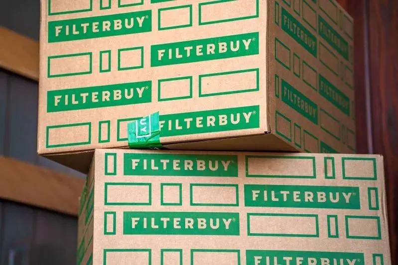 A view of stacked Filterbuy shipping boxes with green branding, representing air filter delivery and bulk packaging.