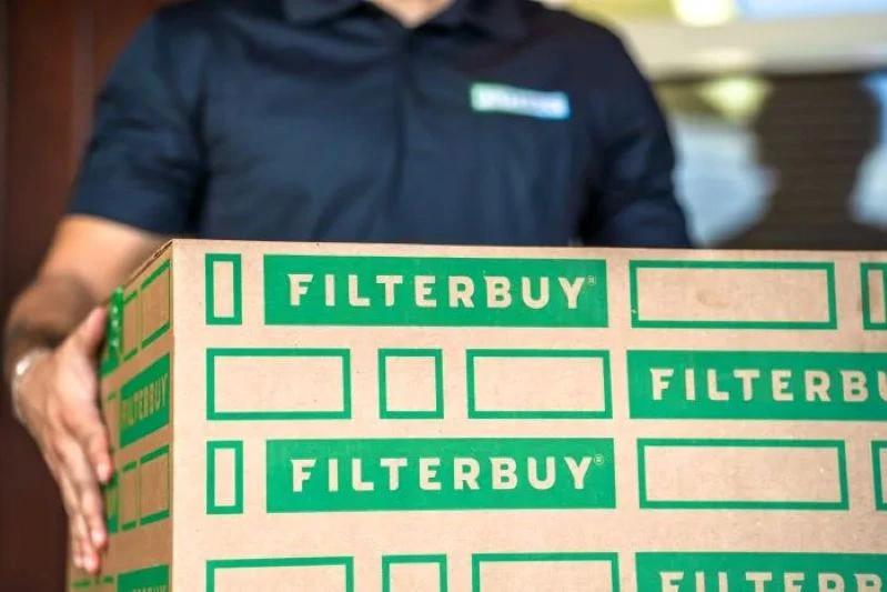 A view of a Filterbuy employee delivering an 18x18x1 air filter package for home installation.