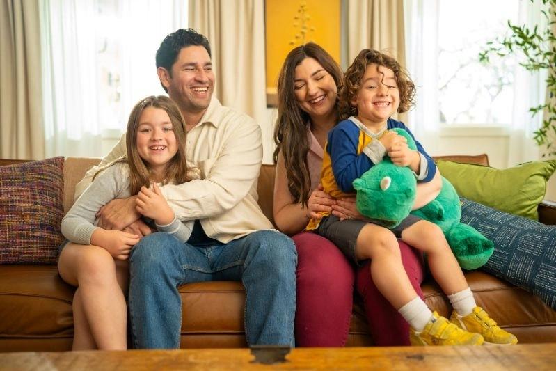Aprilaire 410 Air Filter Replacement Near Me - Image of a happy family sitting on the couch, cuddling their children.