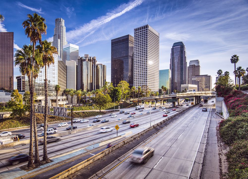 Image of a busy Los Angeles-Long Beach-Anaheim, CA street just beside the towering residential and commercial establishments making up the downtow area.