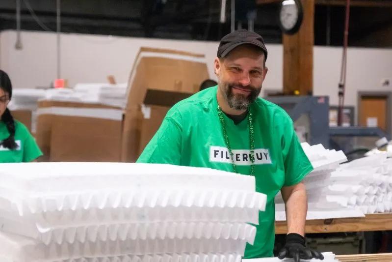 24x36x2 Carbon Air Conditioner Filter Nearby - View of Filterbuy male employee happily arranging air filtration units