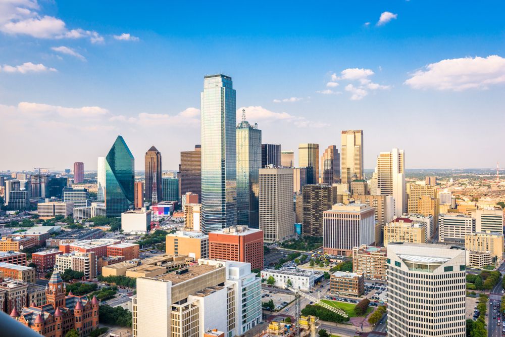 Expansive downtown skyline featuring uniquely shaped skyscrapers under a clear blue sky.