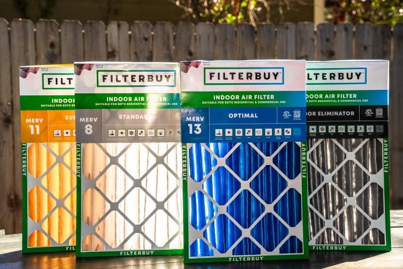 The Ultimate Guide to Cleaning and Maintaining the Best HEPA Air Purifier Replacement Filters - Image of four different MERV rated air filters from FilterBuy, displayed on a table in front of a wooden fence.