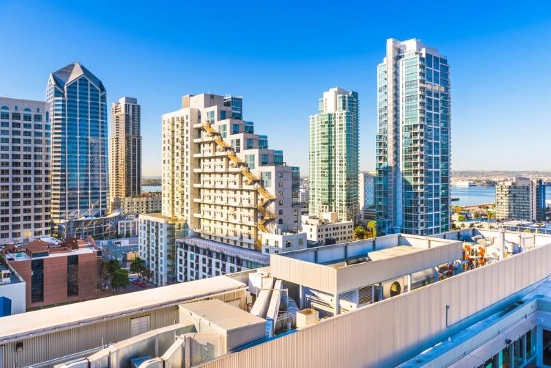 Cities With the Most Multigenerational Households - Image of San Diego cityscape with modern skyscrapers and a bright blue sky, featuring a view of the bay area and downtown buildings.
