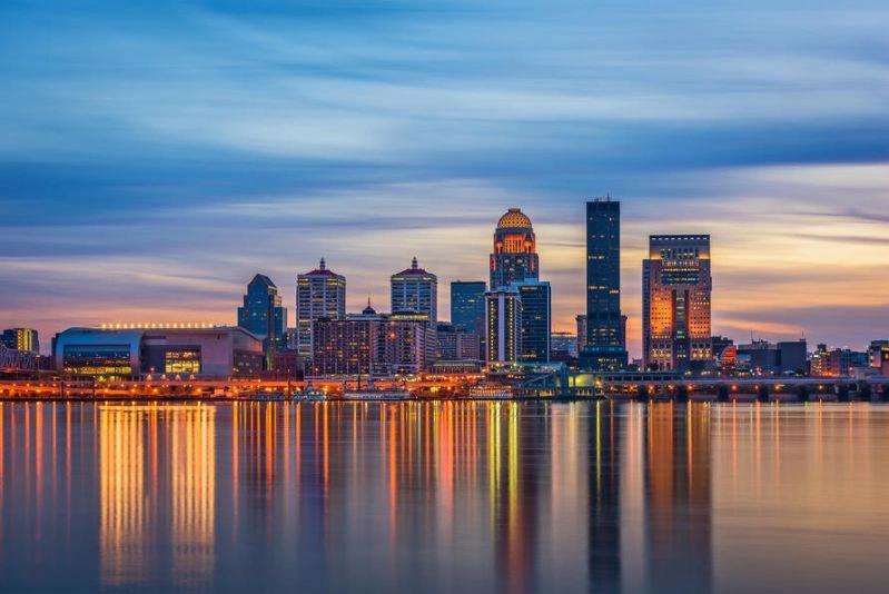 Cities with the Most Asthma Cases - Image of Louisville cityscape with modern skyscrapers and a bright blue sky, featuring a view of the bay area and downtown buildings.