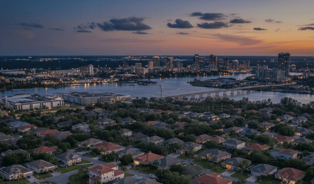An image of a Jacksonville Florida residential neighborhood at sunset with the city skyline and St. Johns River.