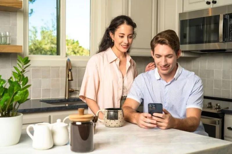 A view of a couple browsing air filter options for allergies on their smartphone.
