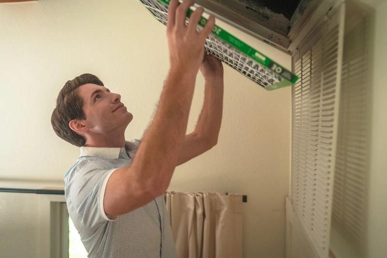 Furnace Humidifier Air Filter for Whole House - An image of a man installing his air filter.