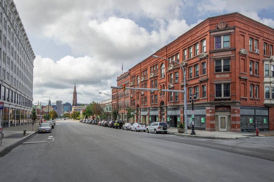 Nighttime view of a brightly lit downtown skyline with skyscrapers and cranes.