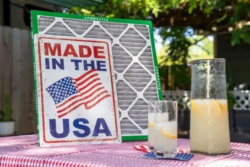 A view of a high-quality Filterbuy air filter proudly Made in the USA, displayed beside fresh lemonade on a sunny outdoor table.