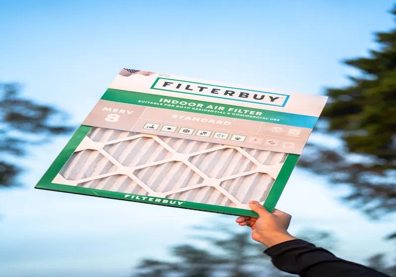 A view of a person holding up a 14x14x4 air filter against a clear blue sky, highlighting its ability to enhance filtration efficiency and improve indoor air quality.