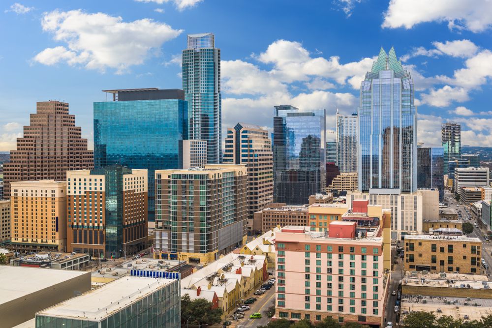 Cluster of modern skyscrapers in a downtown area with partly cloudy skies