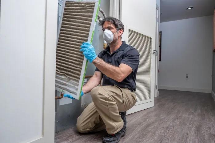 What You Need to Know About Furnace Air Filters - View of a Filterbuy technician taking down a dirty air filter to give way to the best furnace air filters for home.