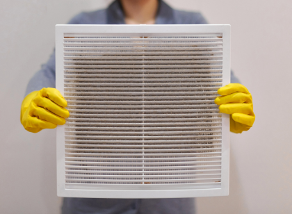 A view of a person holding a dirty air filter.
