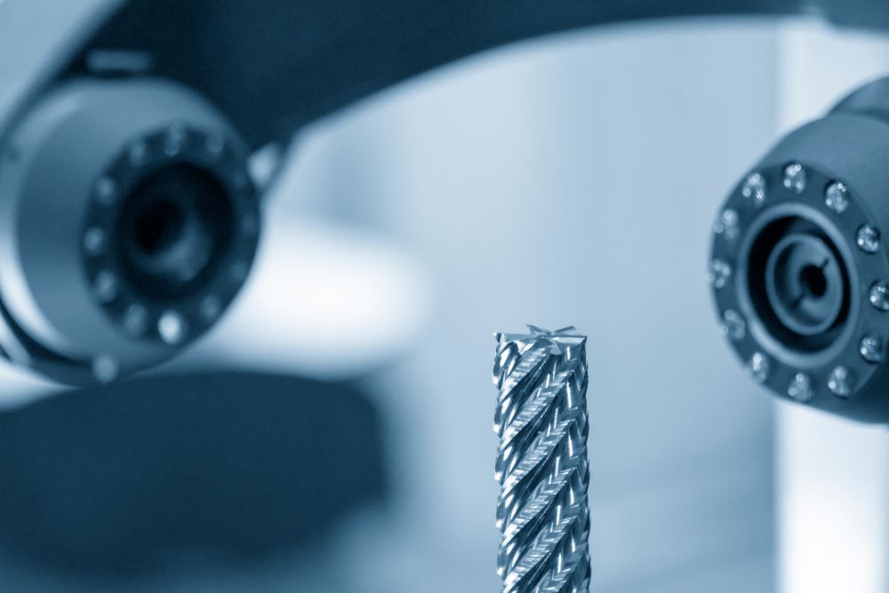 Close-up of industrial CNC machine and milling drill bit representing manufacturing job growth.