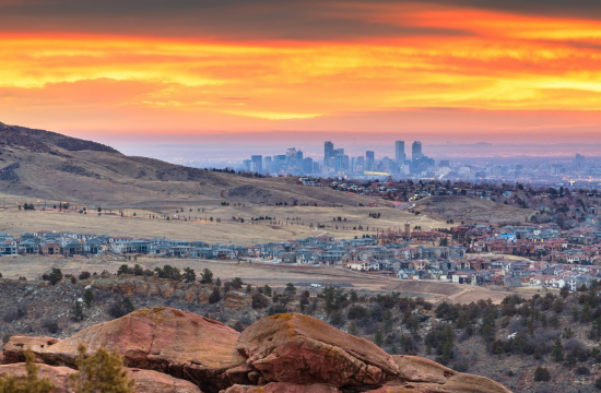 Skyline viewed from a hilly landscape at sunset with rocky foreground