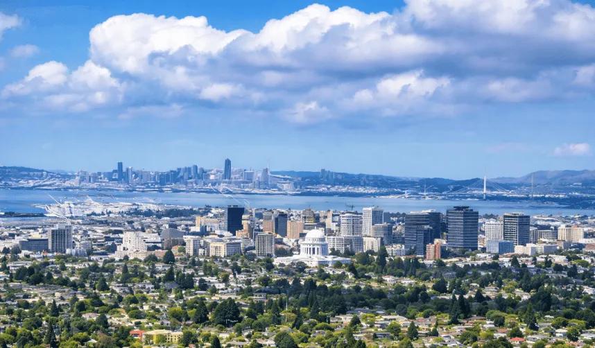 View of Oakland California skyline overlooking residential neighborhoods and the Bay Area under partly cloudy skies, representing today’s live Air Quality Index (AQI) conditions and air pollution levels.