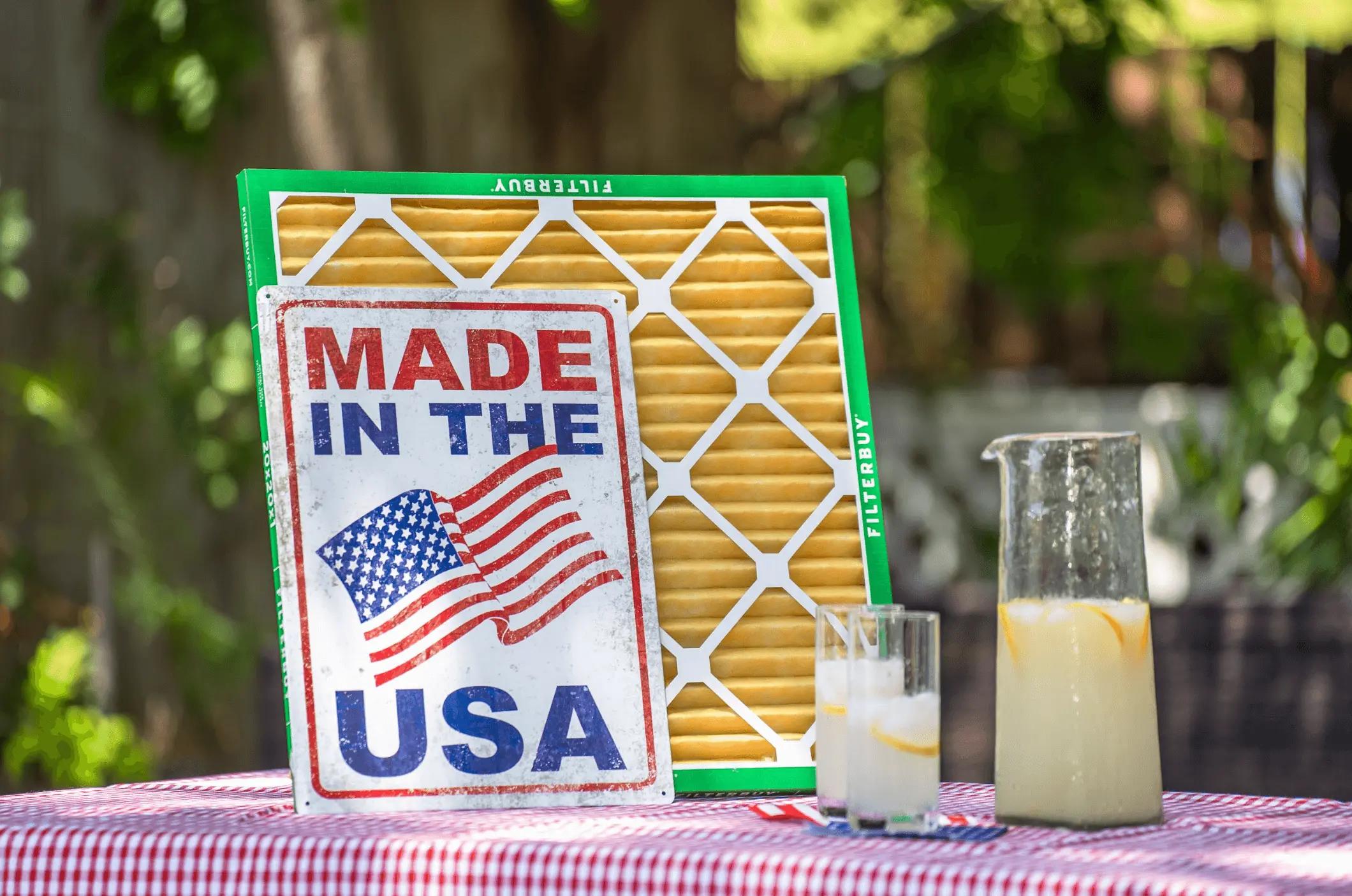 Image of a Filterbuy air filter displayed outdoors with a “Made in the USA” sign and a pitcher of lemonade on a picnic table.